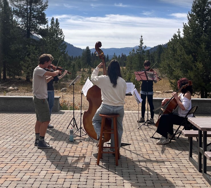 Boise High string musicians performing outdoors in the mountains