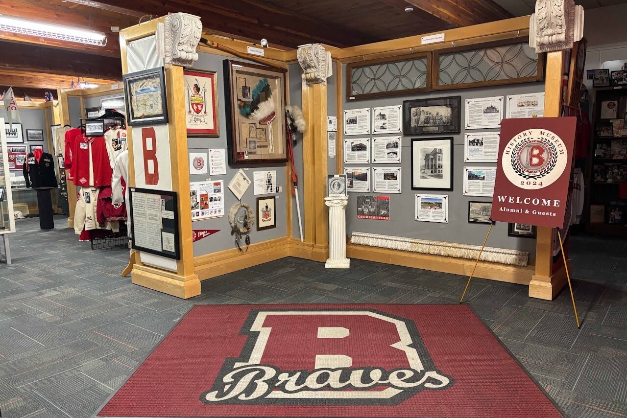 The Boise High School History Museum, with vintage letterman jackets, framed photographs, and a red Braves B rug at the entrance